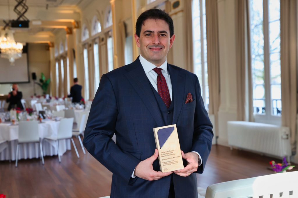 Philip holding the Distinguished Alumni Award trophy