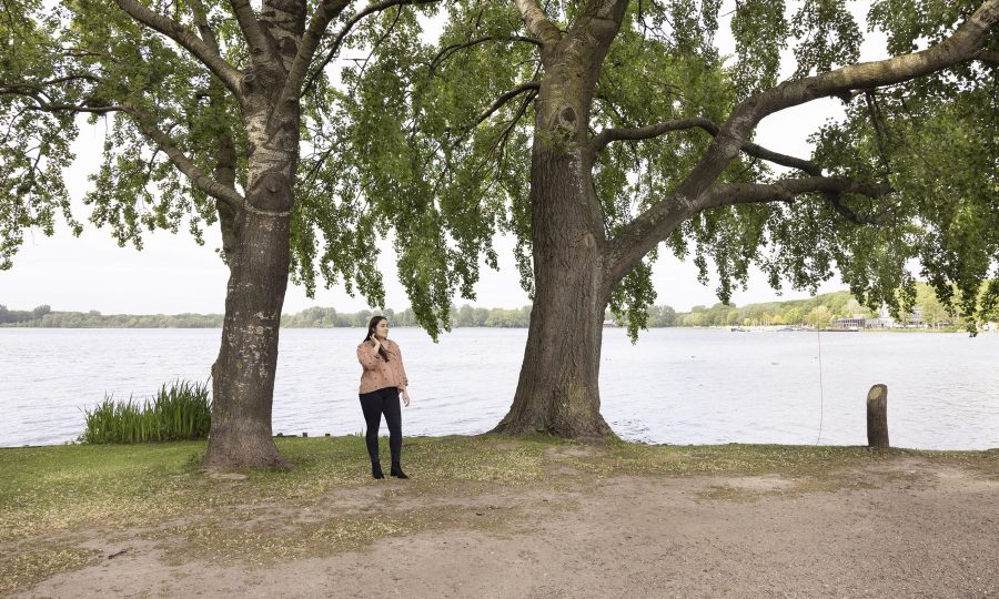 Ivona standing below trees with the lake behind her